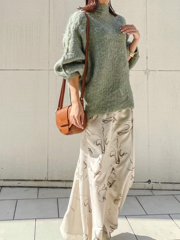 ベージュ系のブーツ、ブラウン系のショルダーバッグ、ホワイト系のスカートを着用したレディースの秋コーディネートの2枚目の写真