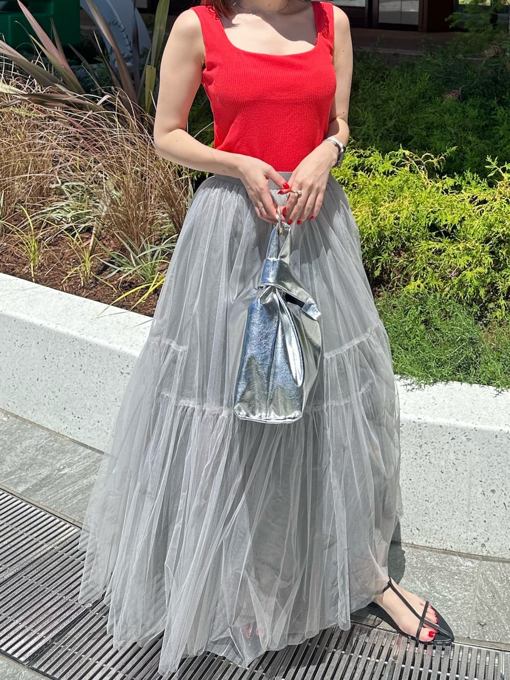 レッド系のタンクトップ、グレー系のスカートを着用したレディースの夏コーディネートの4枚目の写真