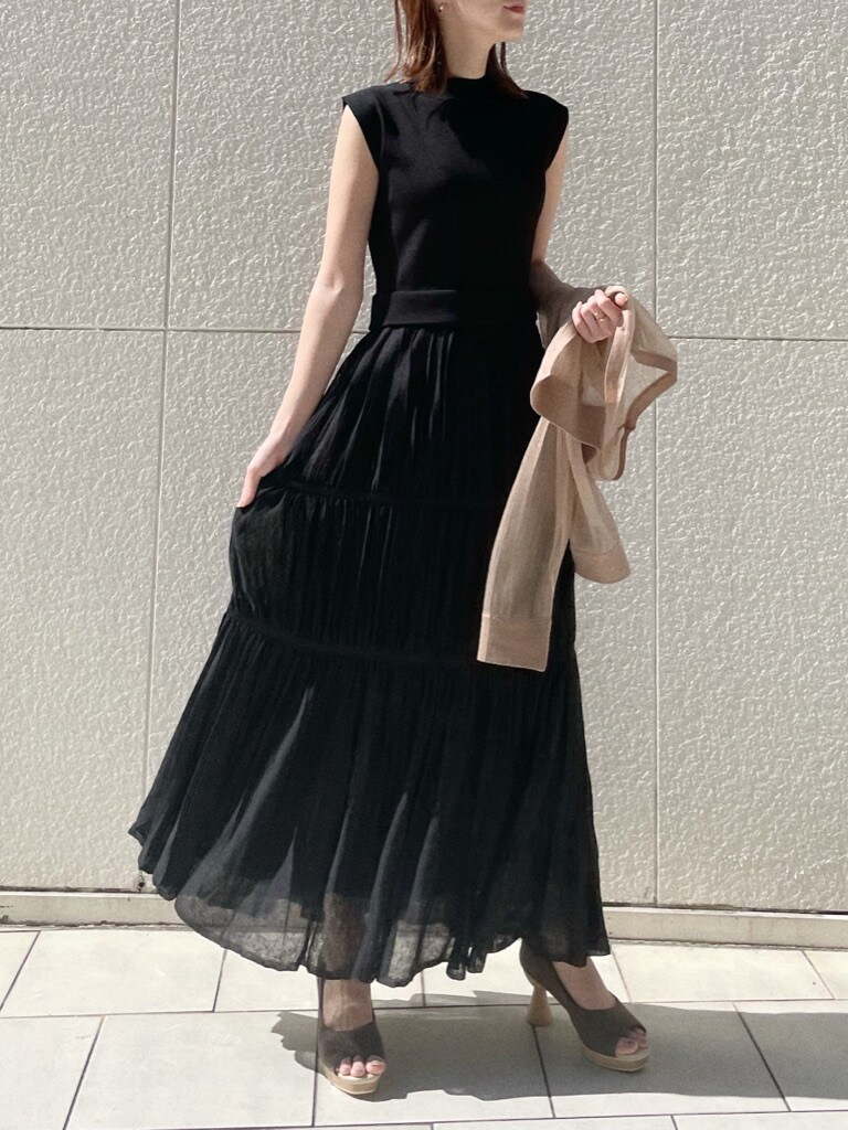 ブラウン系のパンプス、ブラック系のワンピース、ホワイト系のニット/セーターを着用したレディースの春コーディネートの2枚目の写真