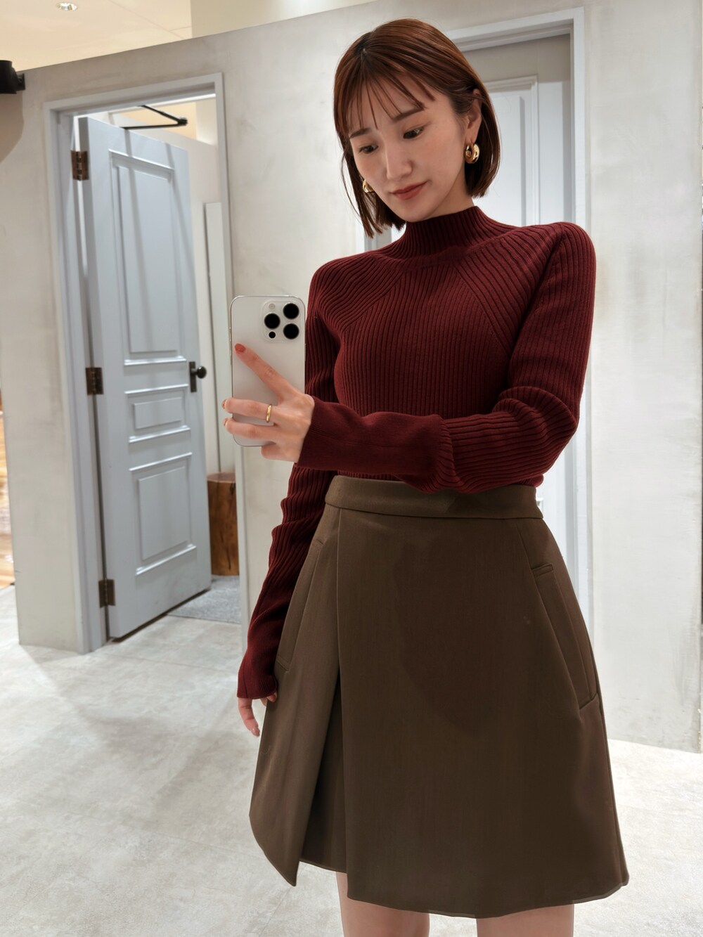 レッド系のニット/セーター、ブラウン系のその他パンツを着用したレディースの秋コーディネートの2枚目の写真