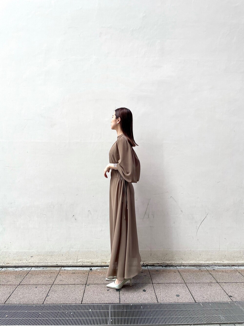 グリーン系のパンプス、ベージュ系のワンピースを着用したレディースの冬コーディネートの2枚目の写真