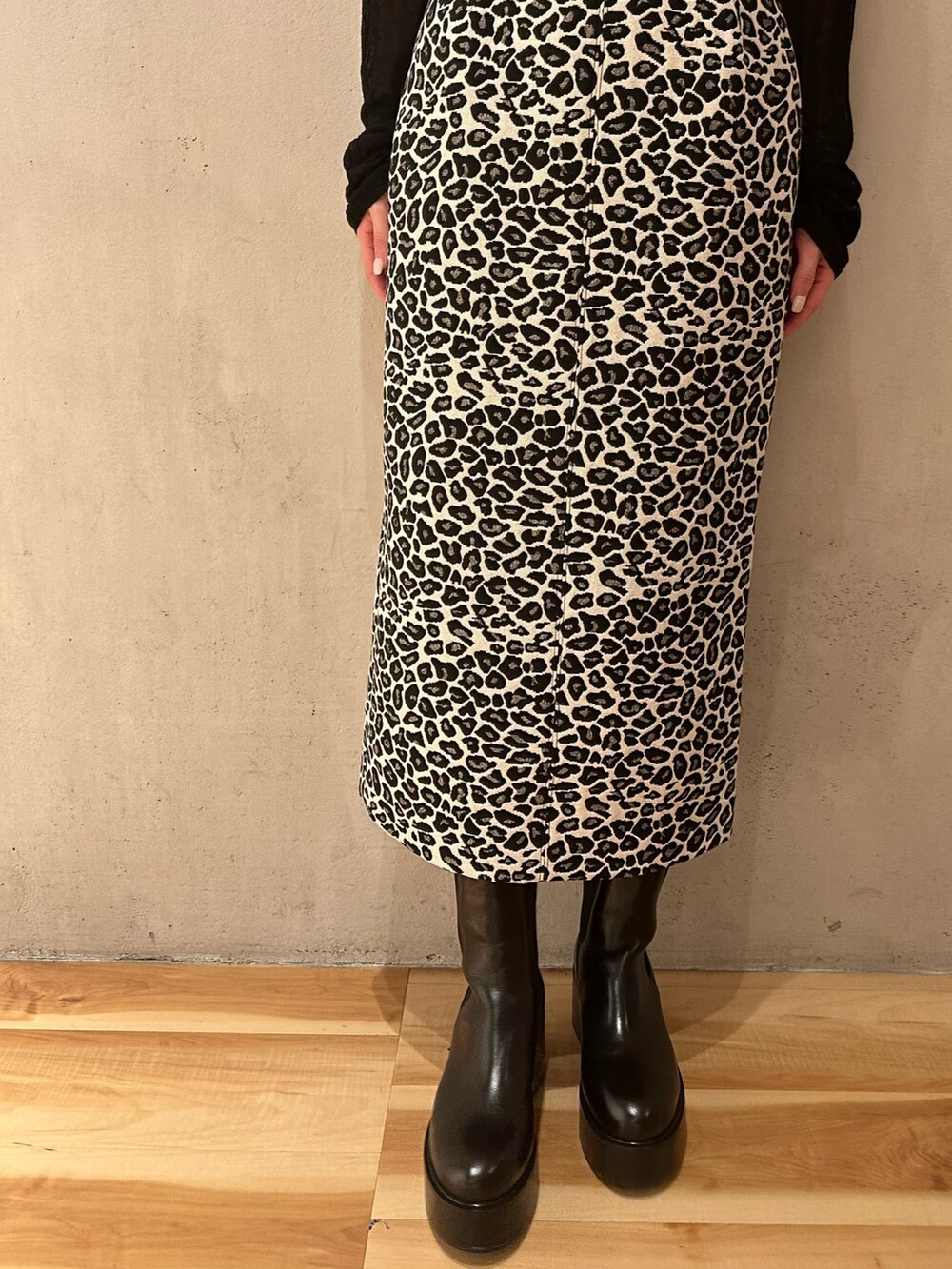 ブラック系のブーツ、ホワイト系のスカート、ブラック系のニット/セーターを着用したレディースの秋コーディネートの5枚目の写真