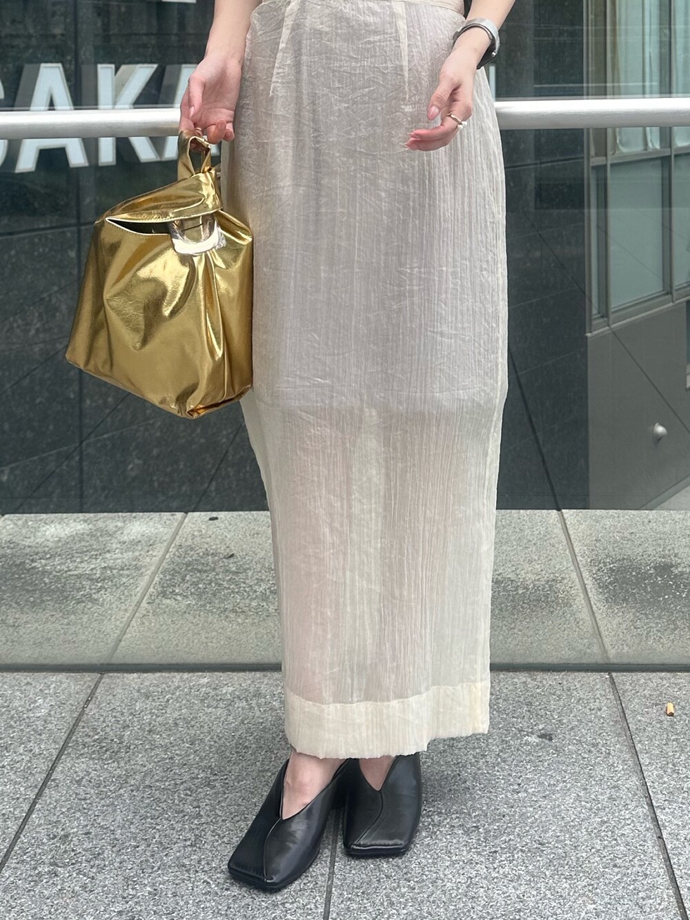 ブラック系のパンプス、ベージュ系のスカート、ブラック系のタンクトップを着用したレディースの夏コーディネートの8枚目の写真