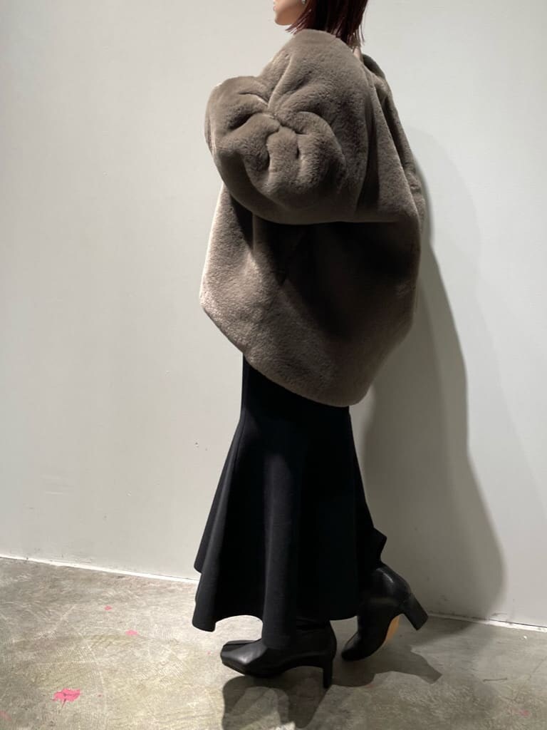 ベージュ系のニット/セーター、ブラウン系のノーカラーコート、ブラック系のブーツを着用したレディースの秋コーディネートの8枚目の写真