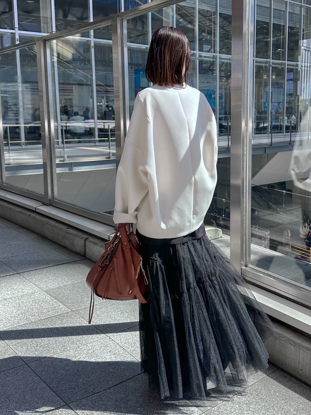 シルバー系のパンプス、ブラック系のスカート、ベージュ系のノーカラーコートを着用したレディースの春コーディネートの4枚目の写真