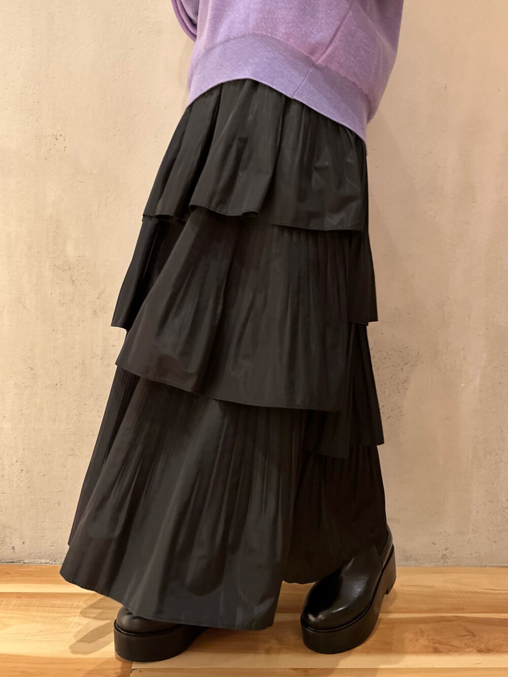 ブラック系のスカート、ホワイト系のノーカラージャケット、パープル系のニット/セーターを着用したレディースの夏コーディネートの4枚目の写真