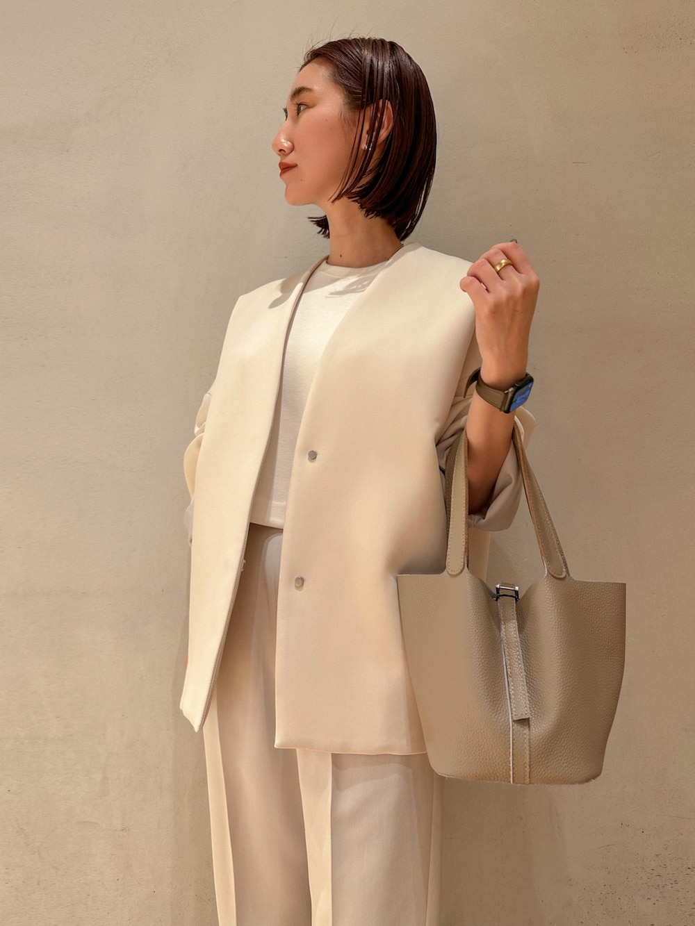 グレー系のその他パンツ、ベージュ系のハンドバッグ、ブラウン系のノーカラーコートを着用したレディースの冬コーディネートの5枚目の写真