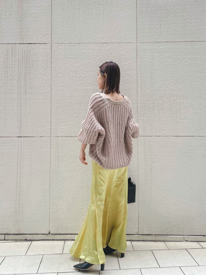 ブラック系のその他シューズ、ベージュ系のカーディガン/ボレロ、イエロー系のスカートを着用したレディースの冬コーディネートの3枚目の写真