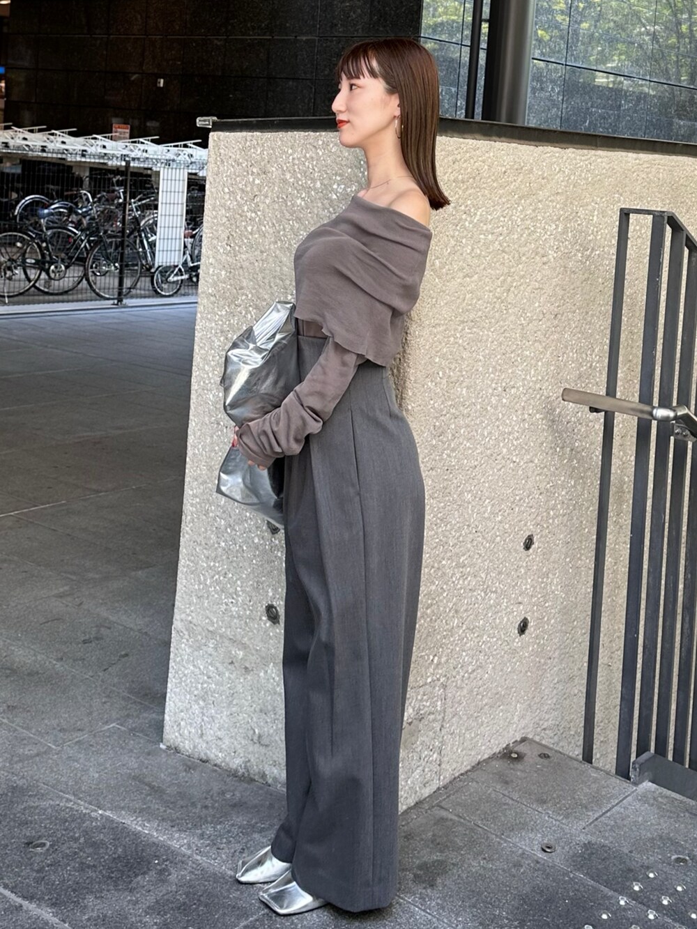 グレー系のニット/セーター、グレー系のその他パンツ、シルバー系のトートバッグを着用したレディースの夏コーディネートの2枚目の写真