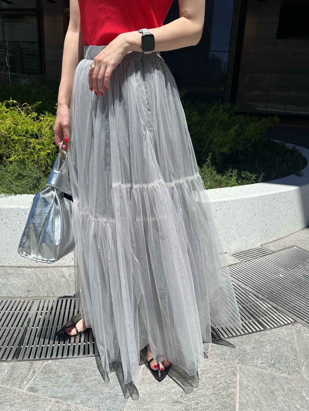 レッド系のタンクトップ、グレー系のスカートを着用したレディースの夏コーディネートの7枚目の写真