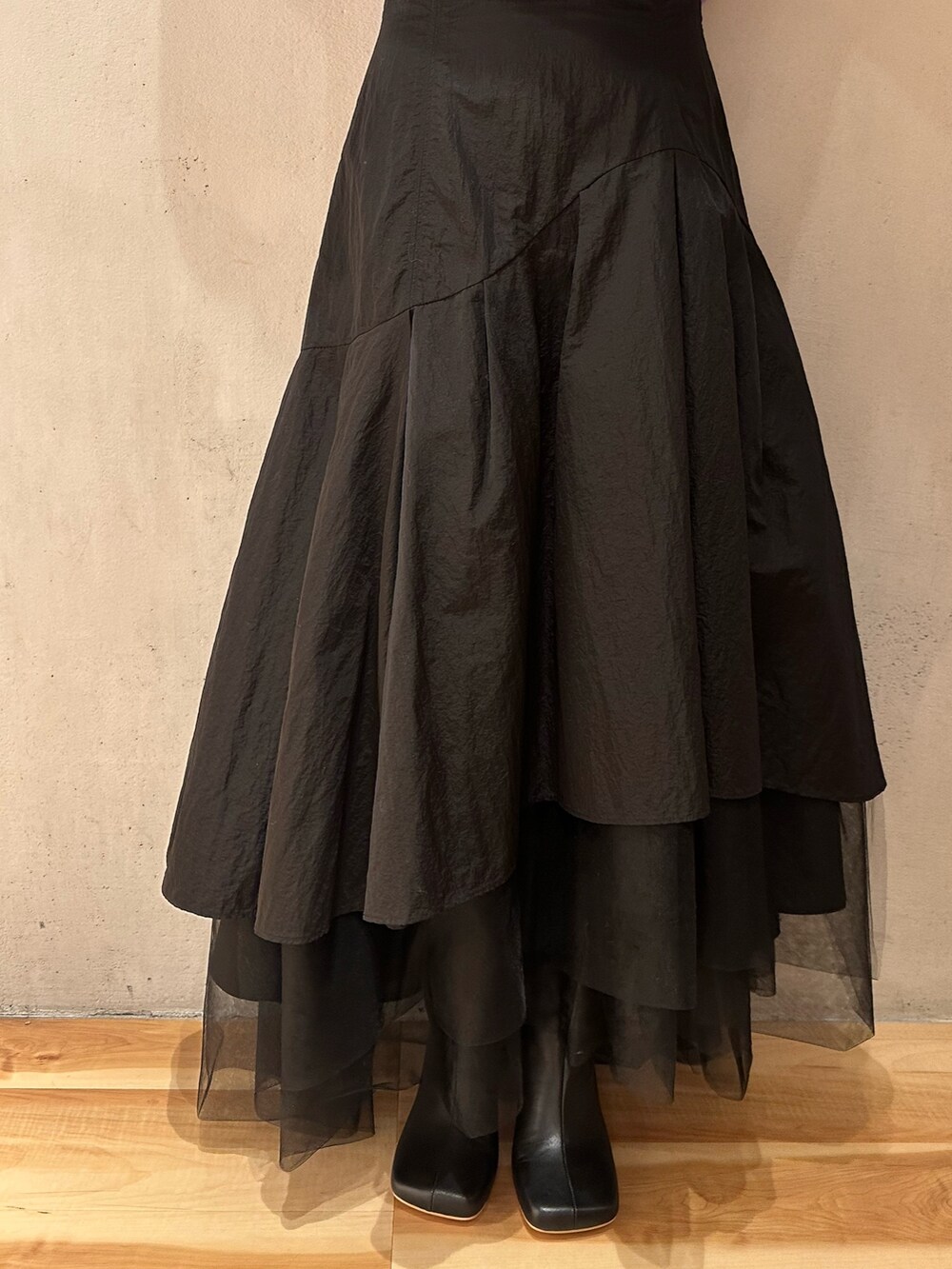 ブラック系のスカート、パープル系のニット/セーター、ブラック系のブーツを着用したレディースの秋コーディネートの9枚目の写真