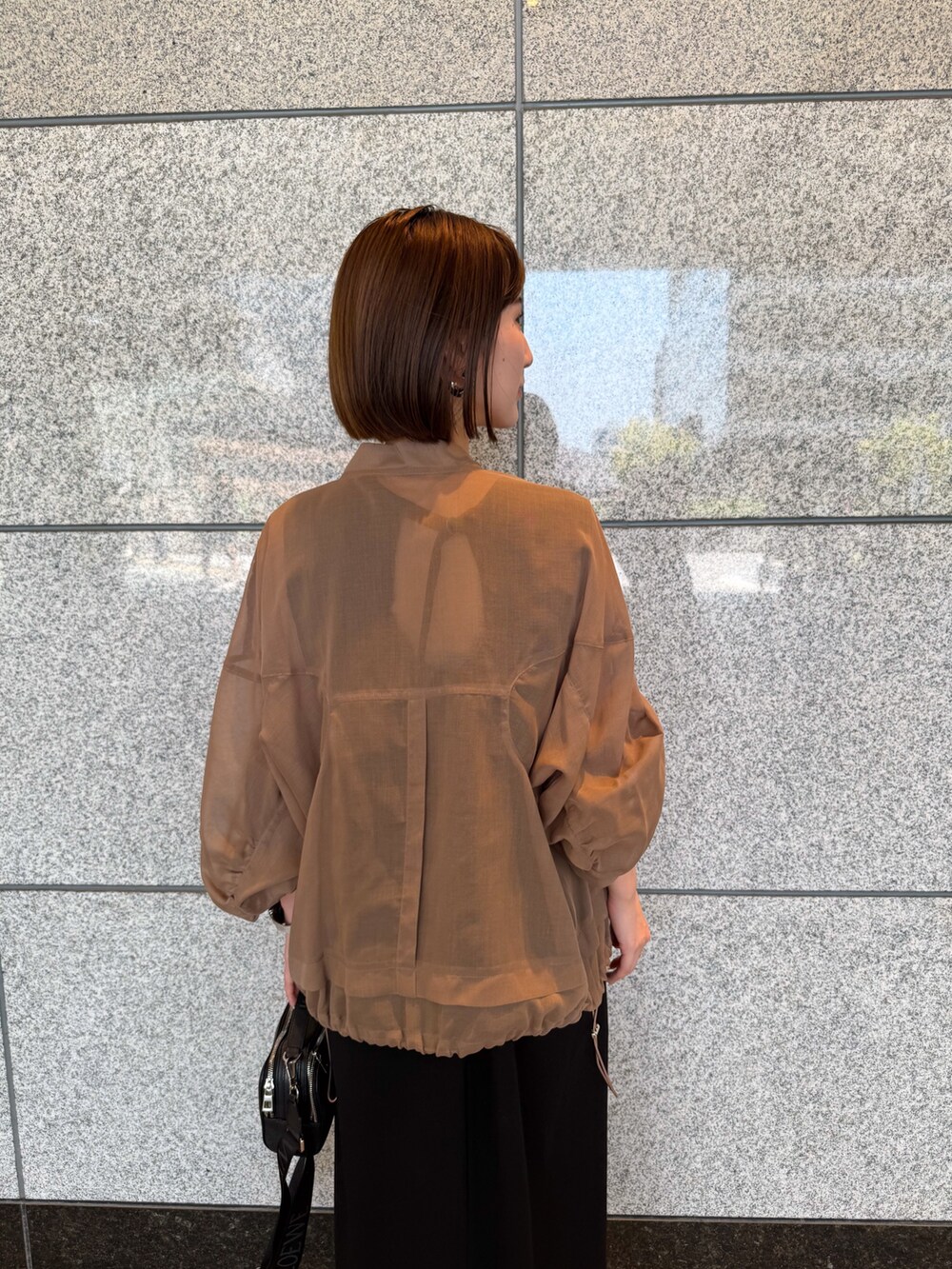 ベージュ系のブルゾン、ブラック系のワンピース、ブラック系のサングラスを着用したレディースの夏コーディネートの8枚目の写真