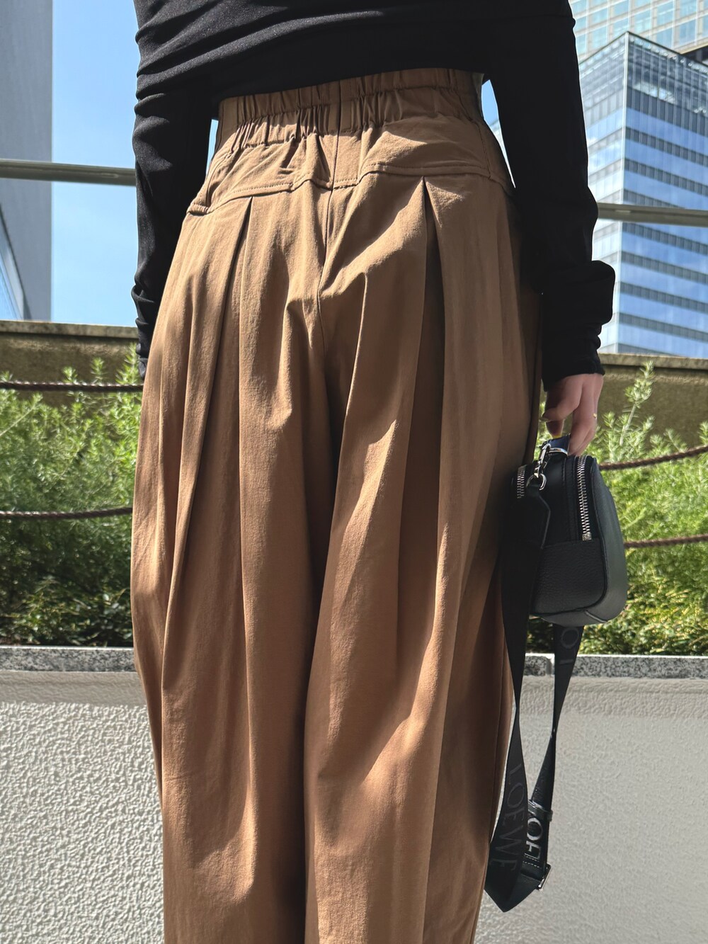 ブラック系のTシャツ/カットソー、ブラック系のサンダル、ブラウン系のその他パンツを着用したレディースの春コーディネートの9枚目の写真