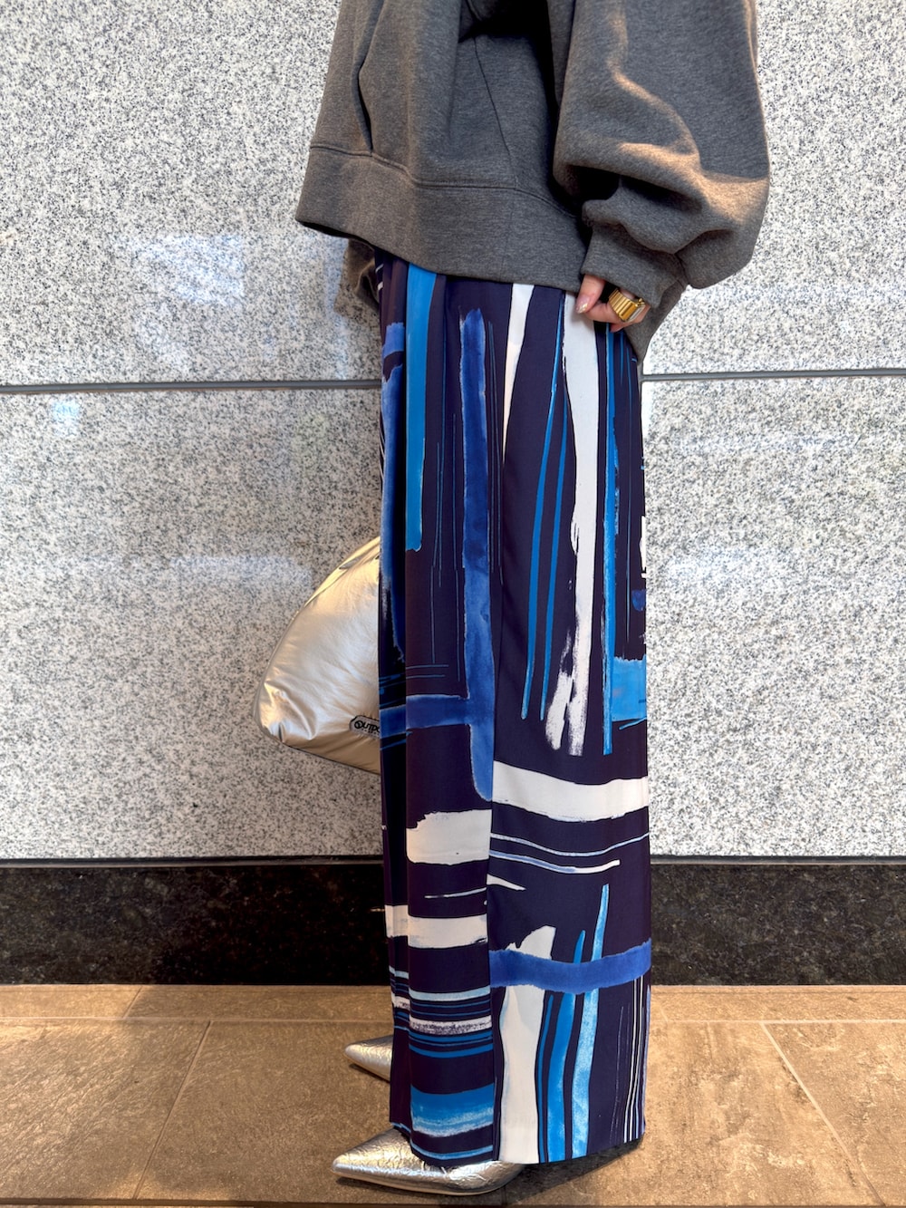 グレー系のTシャツ/カットソー、シルバー系のハンドバッグ、ブルー系のその他パンツを着用したレディースの冬コーディネートの6枚目の写真