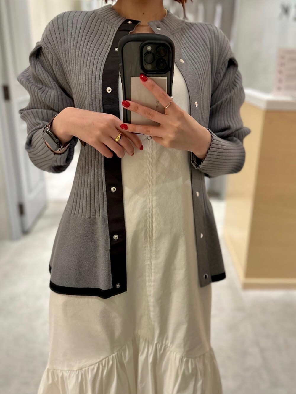 グレー系のニット/セーター、イエロー系のスカート、ホワイト系のスニーカーを着用したレディースの冬コーディネートの2枚目の写真