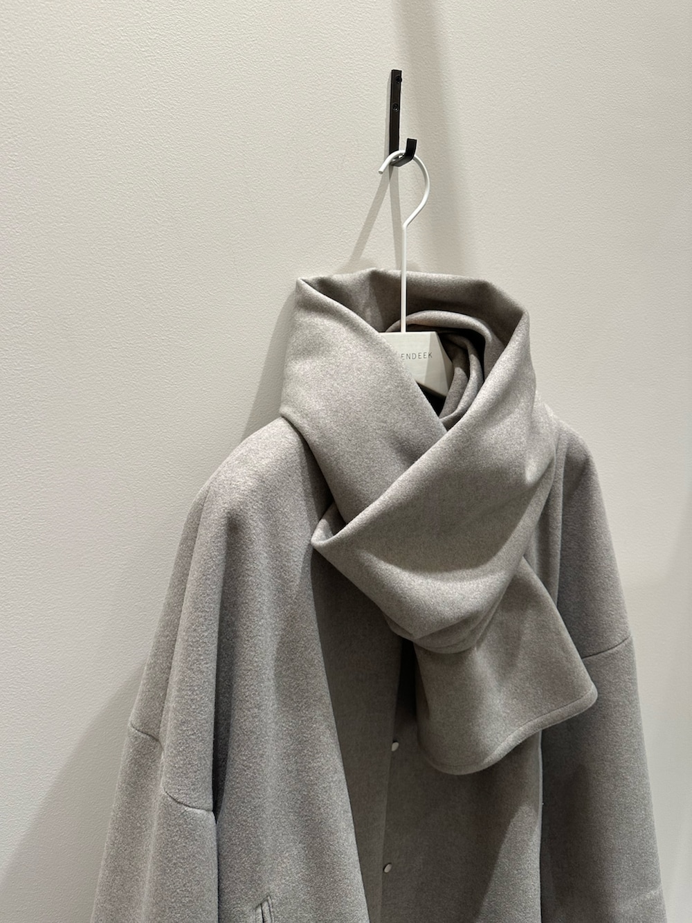 グレー系のステンカラーコート、その他のワンピースを着用したレディースの冬コーディネートの7枚目の写真