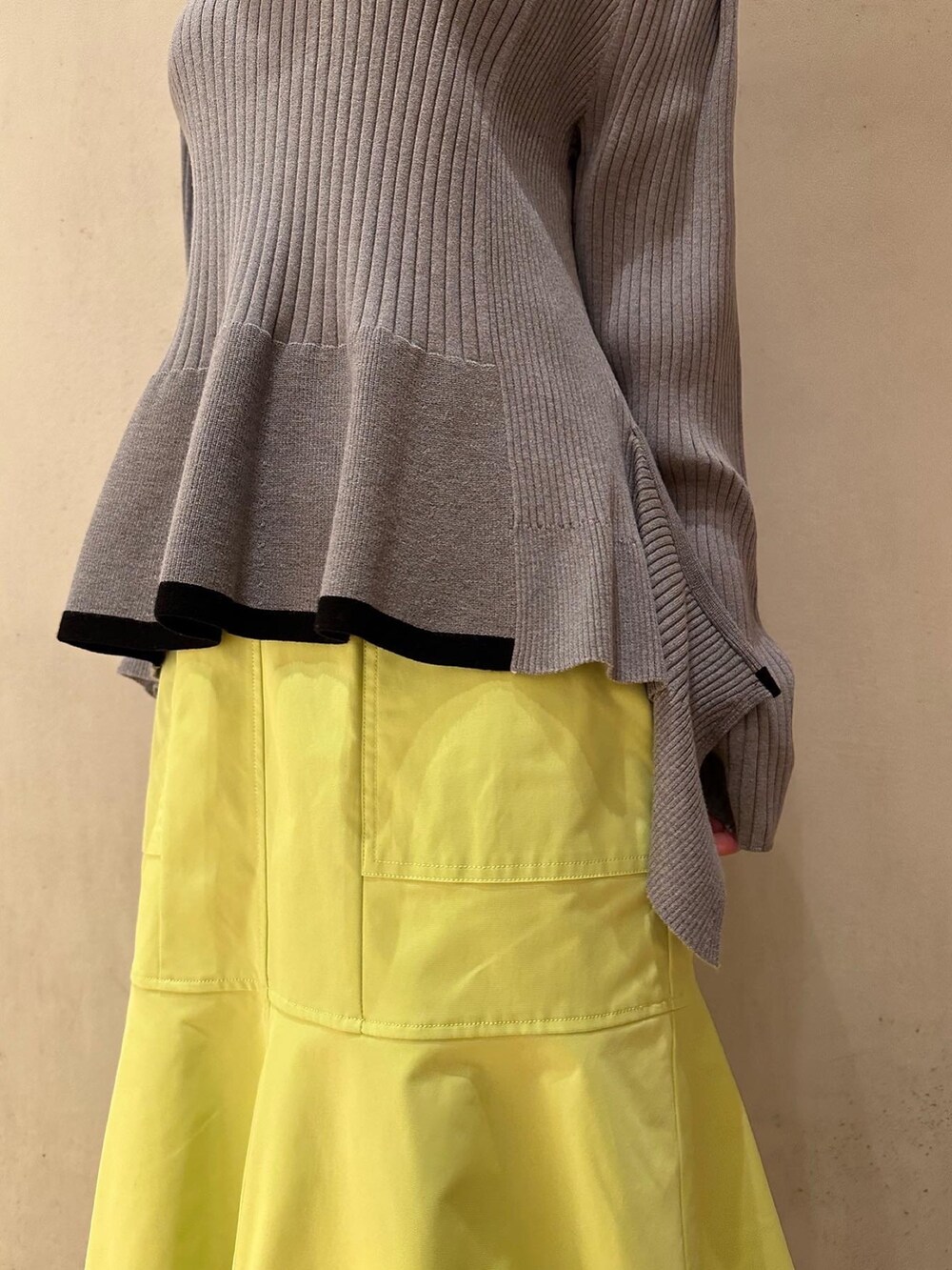 グレー系のニット/セーター、イエロー系のスカート、ホワイト系のスニーカーを着用したレディースの冬コーディネートの5枚目の写真