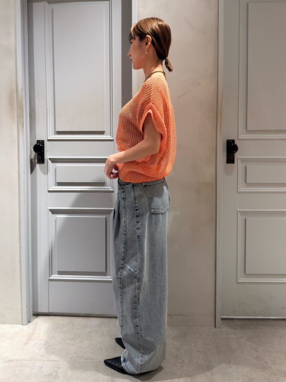 ブルー系のデニムパンツ、ピンク系のニット/セーターを着用したレディースの春コーディネートの2枚目の写真