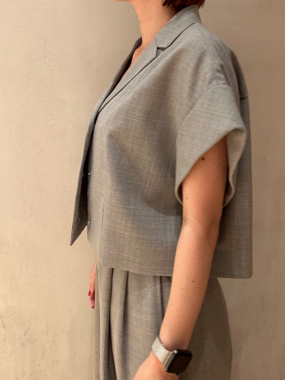 グレー系のテーラードジャケット、ブラック系のショルダーバッグ、ブラック系のバレエシューズを着用したレディースの夏コーディネートの6枚目の写真