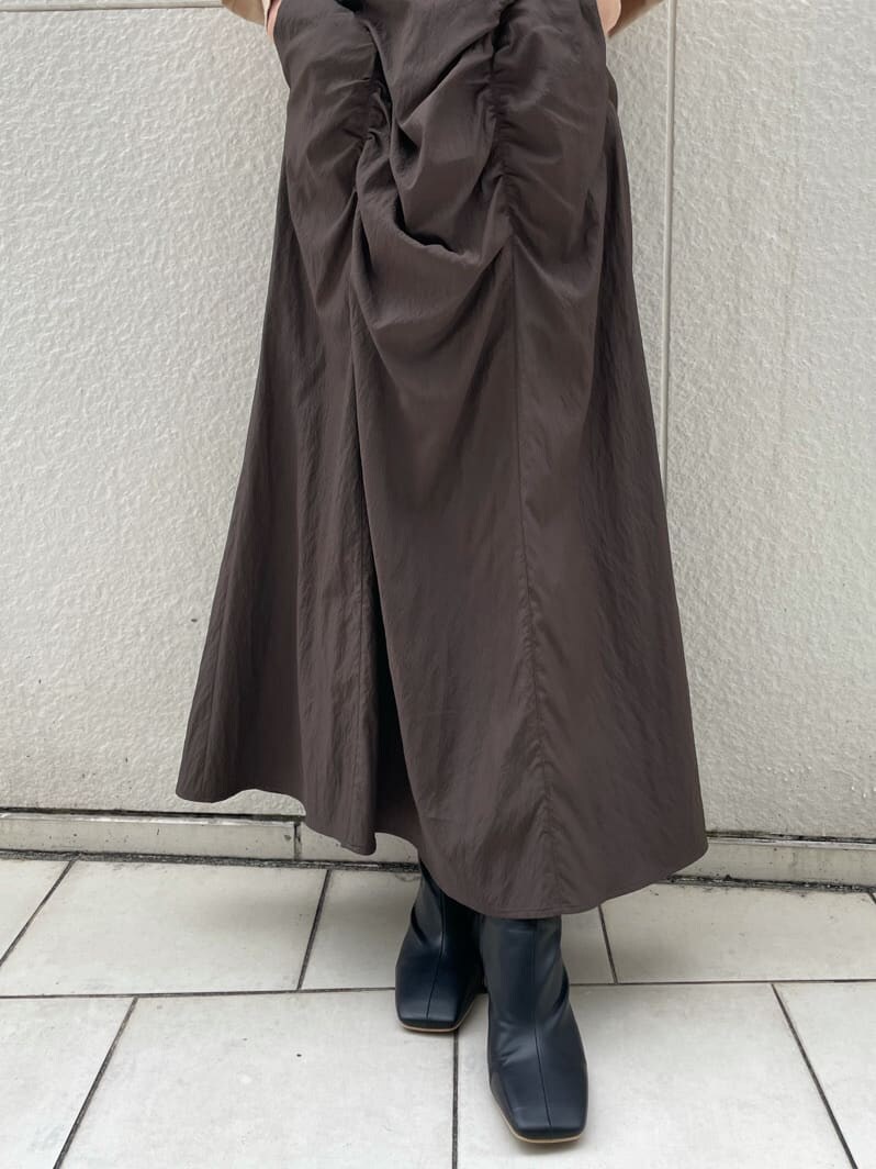 ブラック系のその他シューズ、ホワイト系のハンドバッグ、ブラウン系のスカートを着用したレディースの秋コーディネートの7枚目の写真