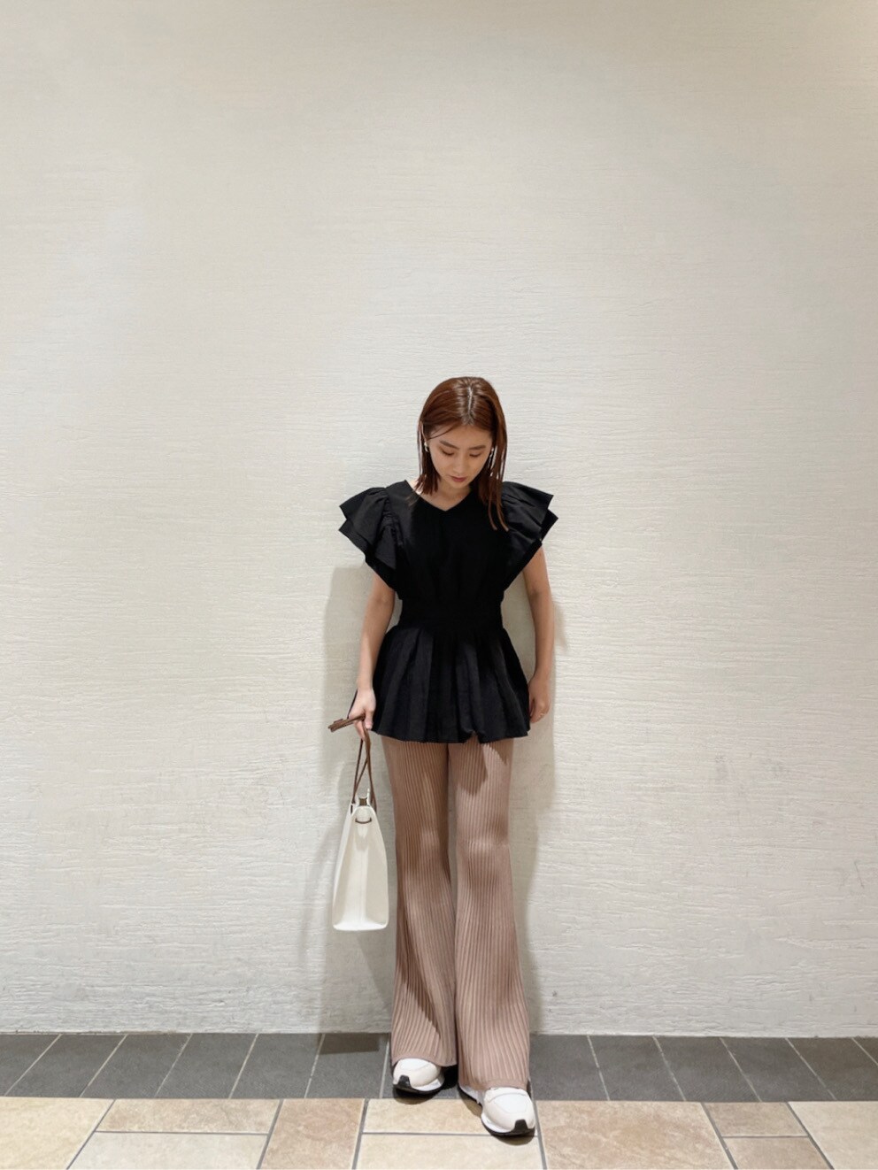 ホワイト系のハンドバッグ、ホワイト系のスニーカー、ブラック系のシャツ/ブラウスを着用したレディースの春コーディネートの3枚目の写真