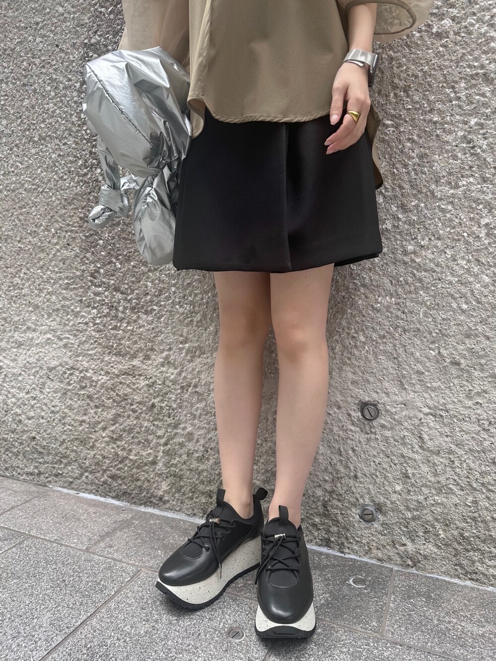 ベージュ系のシャツ/ブラウス、ブラック系のその他パンツ、シルバー系のショルダーバッグを着用したレディースの春コーディネートの7枚目の写真