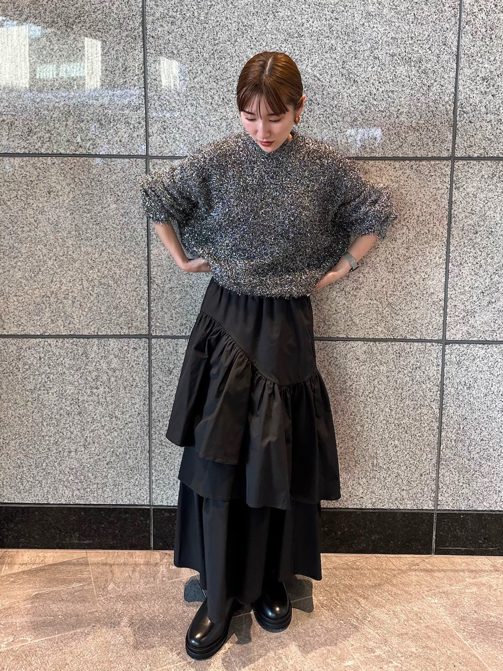 ブラック系のニット/セーター、ブラック系のスカートを着用したレディースの秋コーディネートの9枚目の写真