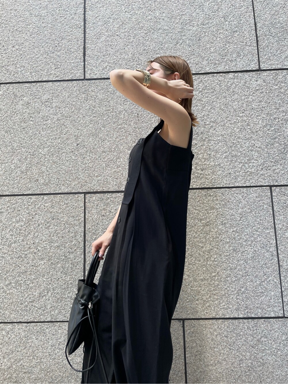 ベージュ系のサンダル、ブラック系のサロペット/オーバーオール、ゴールド系のバングル/リストバンドを着用したレディースの春コーディネートの5枚目の写真