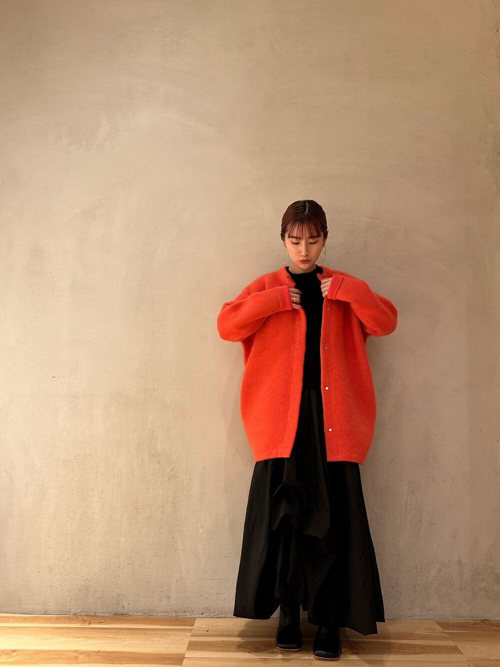 ブラック系のニット/セーター、ブラック系のブーツ、ピンク系のノーカラージャケットを着用したレディースの夏コーディネートの3枚目の写真