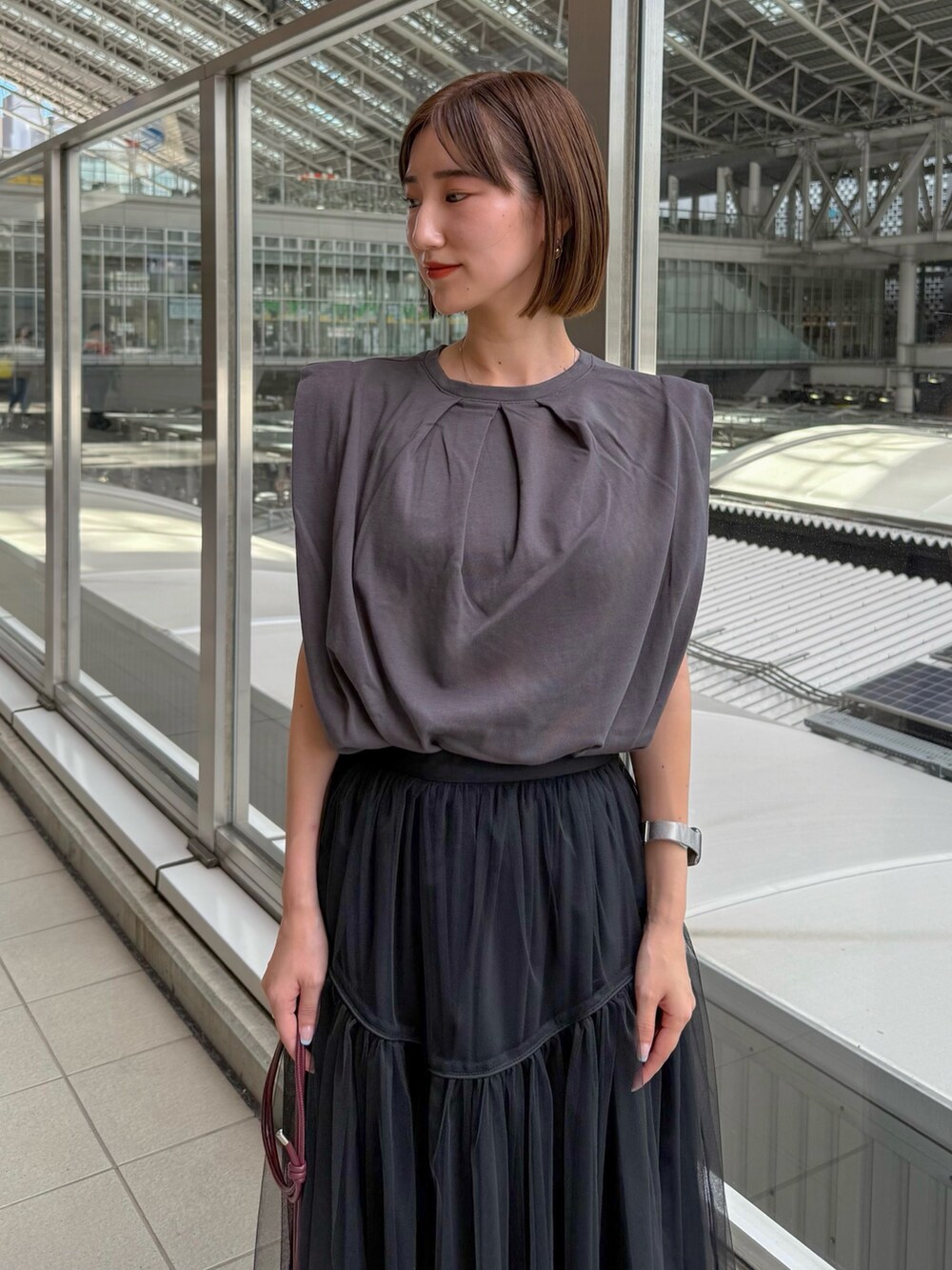 グレー系のTシャツ/カットソー、ブラック系のスカート、レッド系のショルダーバッグを着用したレディースの夏コーディネートの3枚目の写真