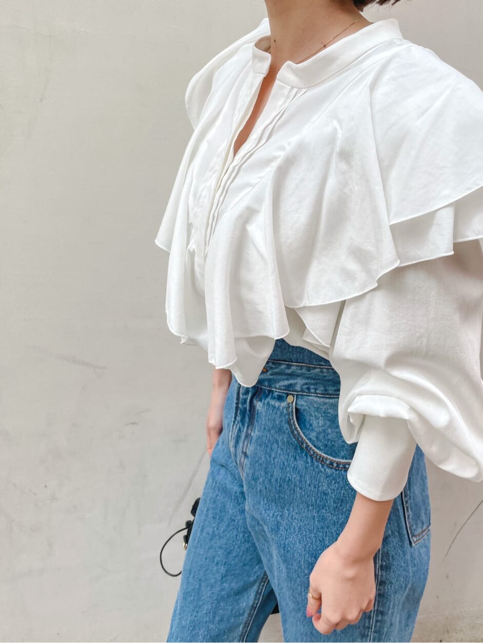 ベージュ系のパンプス、ブラック系のハンドバッグ、ブルー系のデニムパンツを着用したレディースの冬コーディネートの7枚目の写真