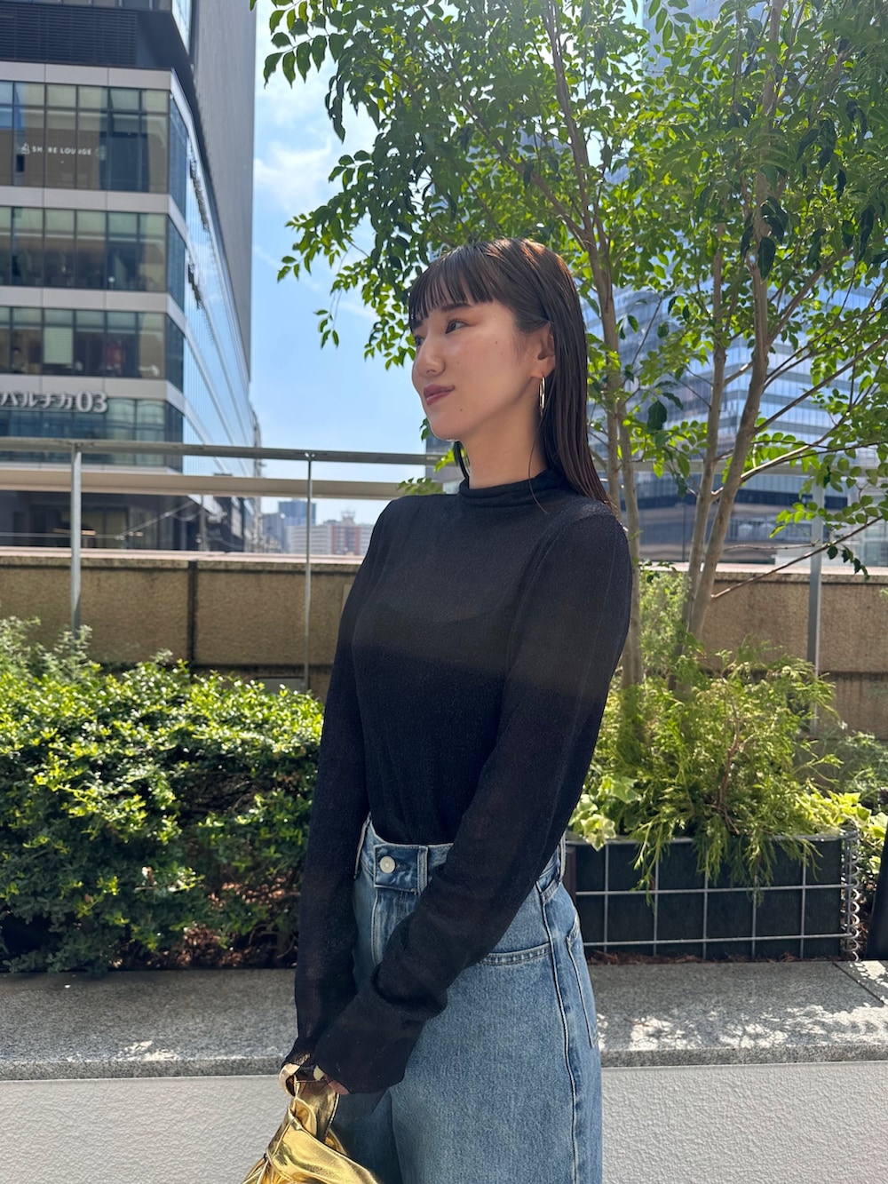 ブルー系のデニムパンツ、ブラック系のパンプス、ブラック系のニット/セーターを着用したレディースの夏コーディネートの6枚目の写真