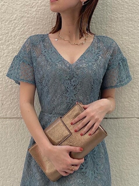 ゴールド系のハンドバッグ、ブルー系のドレス、ゴールド系のネックレスを着用したレディースの夏コーディネートの3枚目の写真