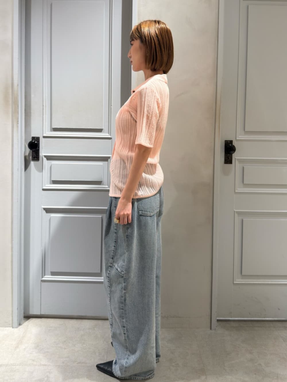 ブルー系のデニムパンツ、ピンク系のニット/セーターを着用したレディースの春コーディネートの2枚目の写真