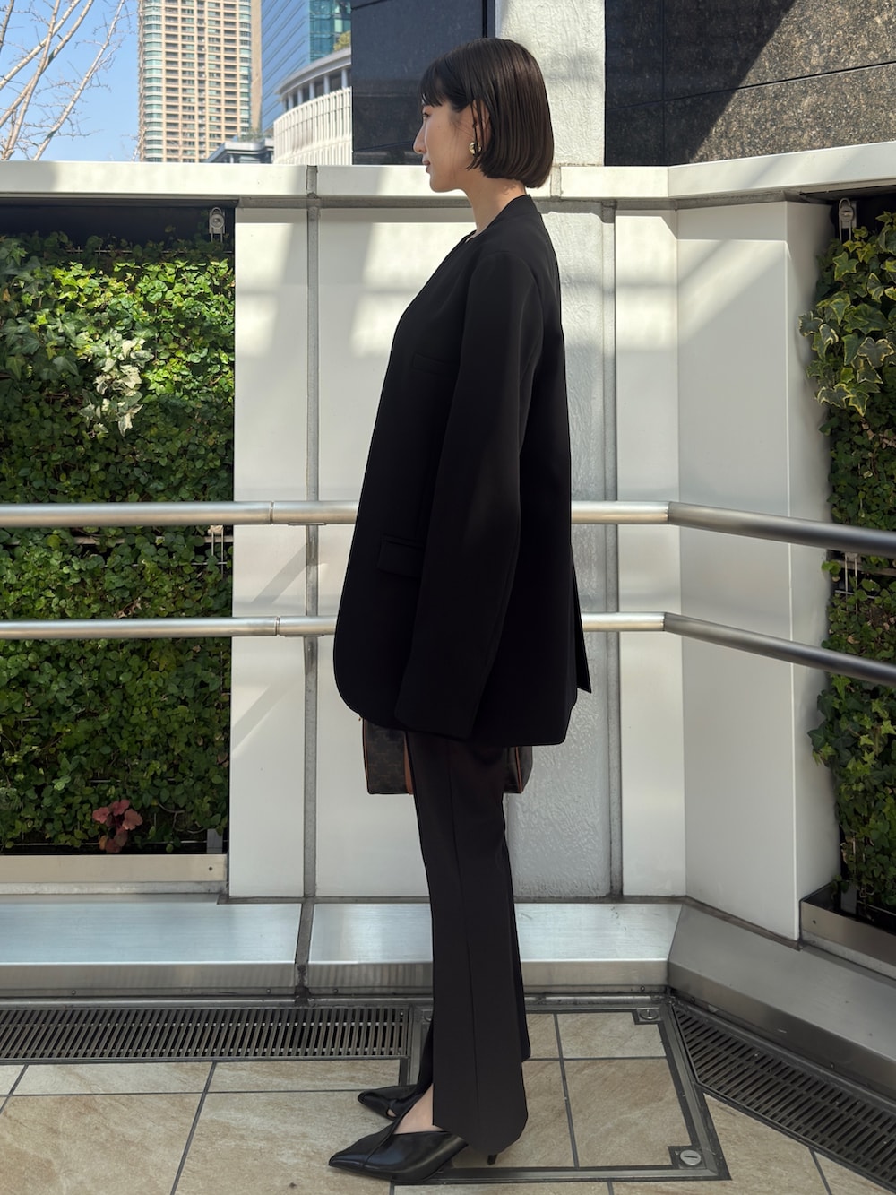 ブラック系のノーカラージャケット、ブラック系のその他パンツ、ブラック系のパンプスを着用したレディースの冬コーディネートの2枚目の写真