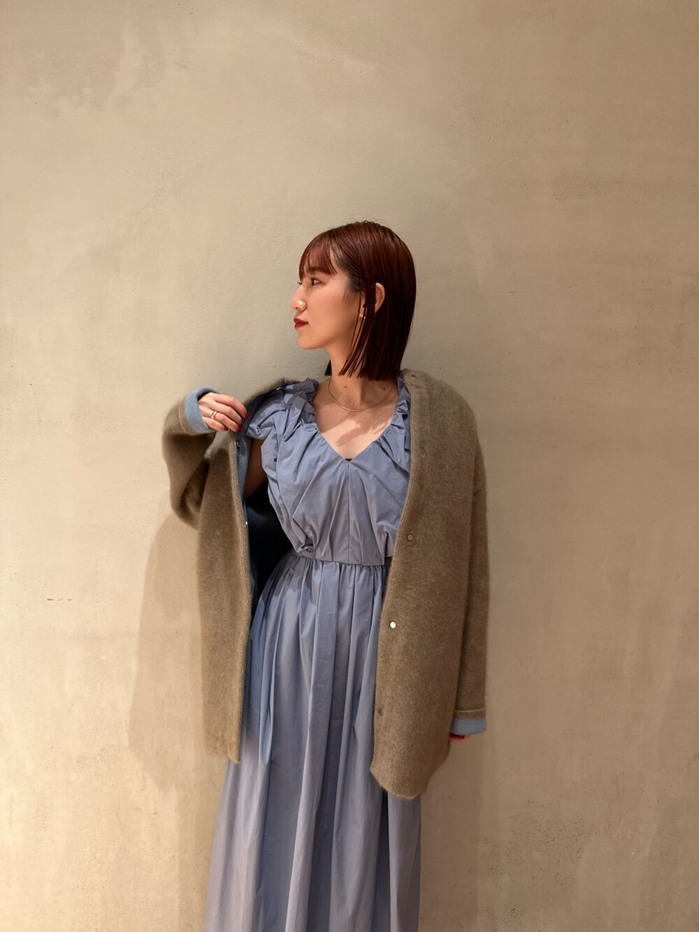 ブルー系のワンピース、ホワイト系のスニーカー、ベージュ系のノーカラージャケットを着用したレディースの夏コーディネートの4枚目の写真