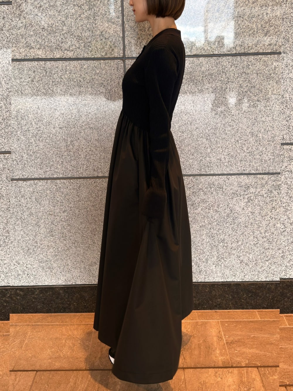 ブラック系のワンピース、ブラック系のスニーカーを着用したレディースの春コーディネートの4枚目の写真