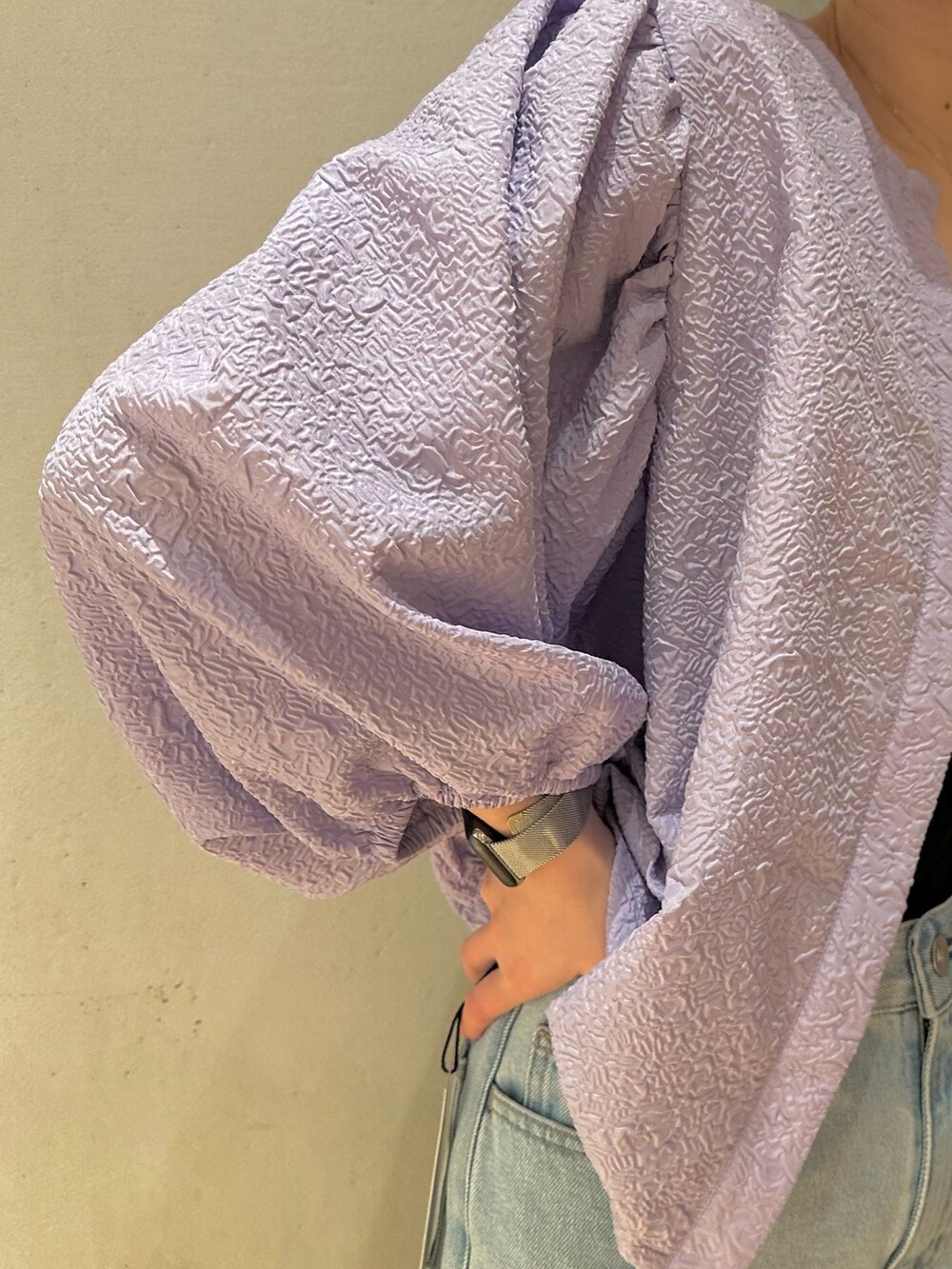 ブルー系のデニムパンツ、シルバー系のパンプス、パープル系のブルゾンを着用したレディースの冬コーディネートの5枚目の写真