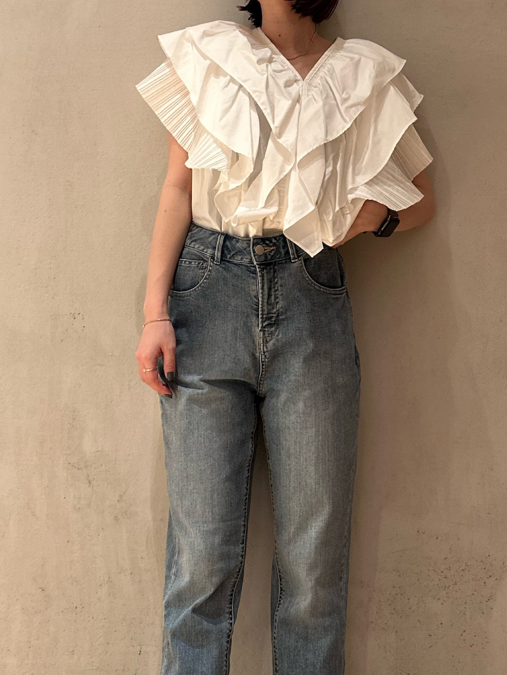 ホワイト系のシャツ/ブラウス、ブラック系のスニーカー、ブルー系のデニムパンツを着用したレディースの春コーディネートの3枚目の写真