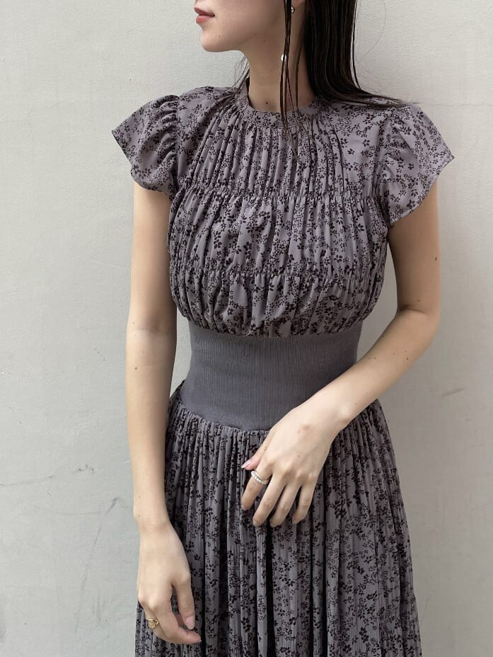 グレー系のワンピース、ホワイト系のカーディガン/ボレロ、ホワイト系のピアス（両耳用）を着用したレディースの秋コーディネートの6枚目の写真