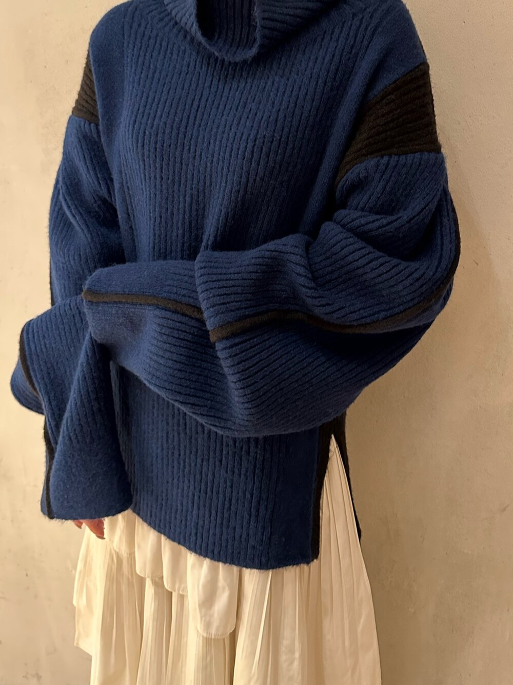 ホワイト系のスカート、ブルー系のニット/セーター、ベージュ系のノーカラーコートを着用したレディースの秋コーディネートの6枚目の写真