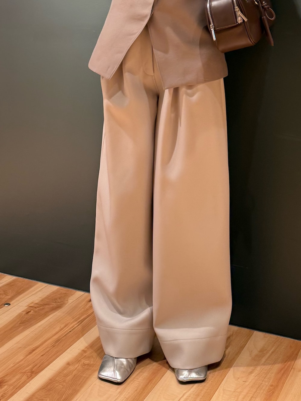 ベージュ系のベスト、ホワイト系のその他パンツ、ブラック系のボストンバッグを着用したレディースの冬コーディネートの7枚目の写真