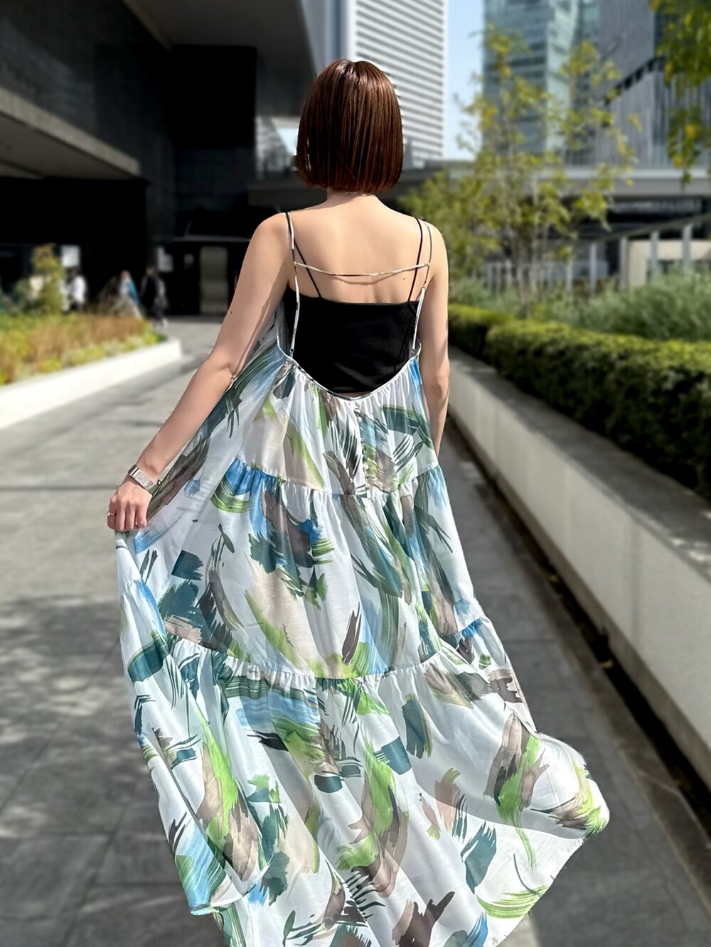 グリーン系のワンピース、シルバー系のトートバッグ、シルバー系のサンダルを着用したレディースの春コーディネートの5枚目の写真