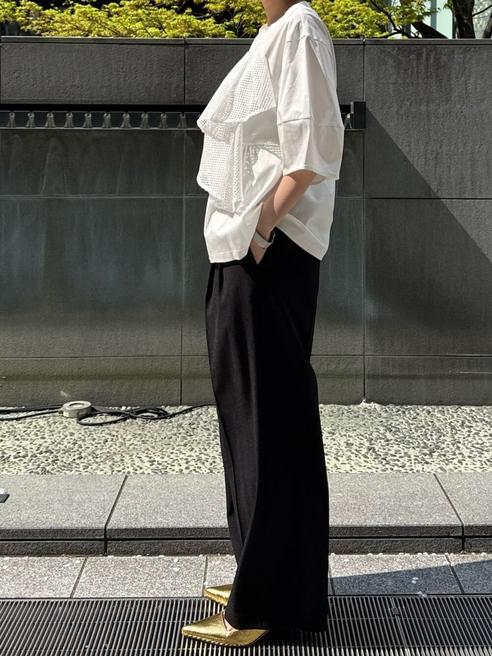 ブラック系のその他パンツ、ゴールド系のサンダル、ホワイト系のTシャツ/カットソーを着用したレディースの春コーディネートの3枚目の写真
