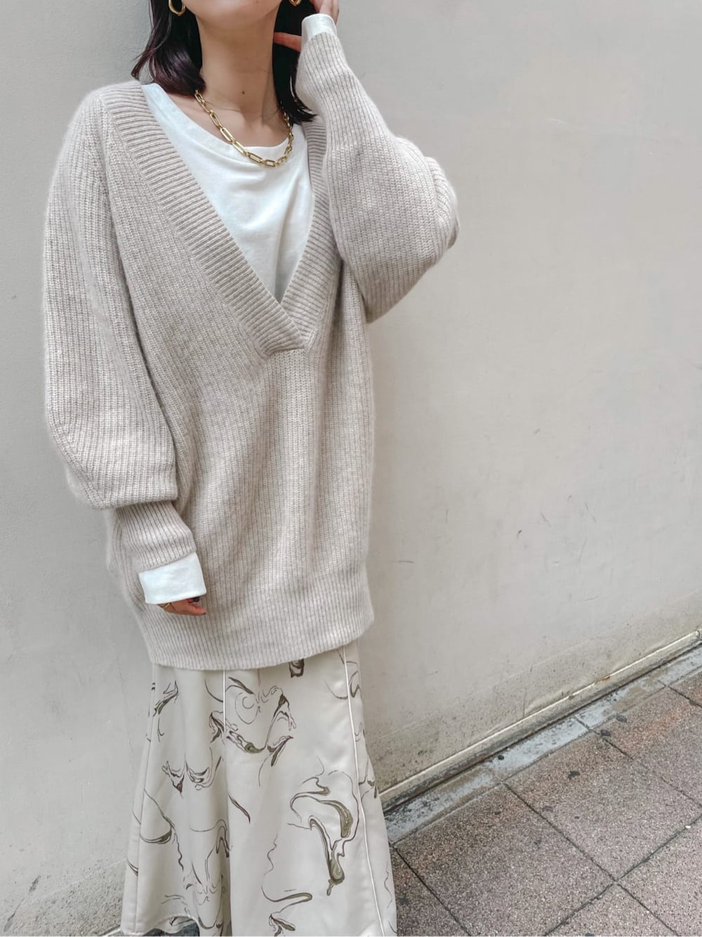 ホワイト系のスカート、ホワイト系のニット/セーター、ホワイト系のTシャツ/カットソーを着用したレディースの秋コーディネートの4枚目の写真