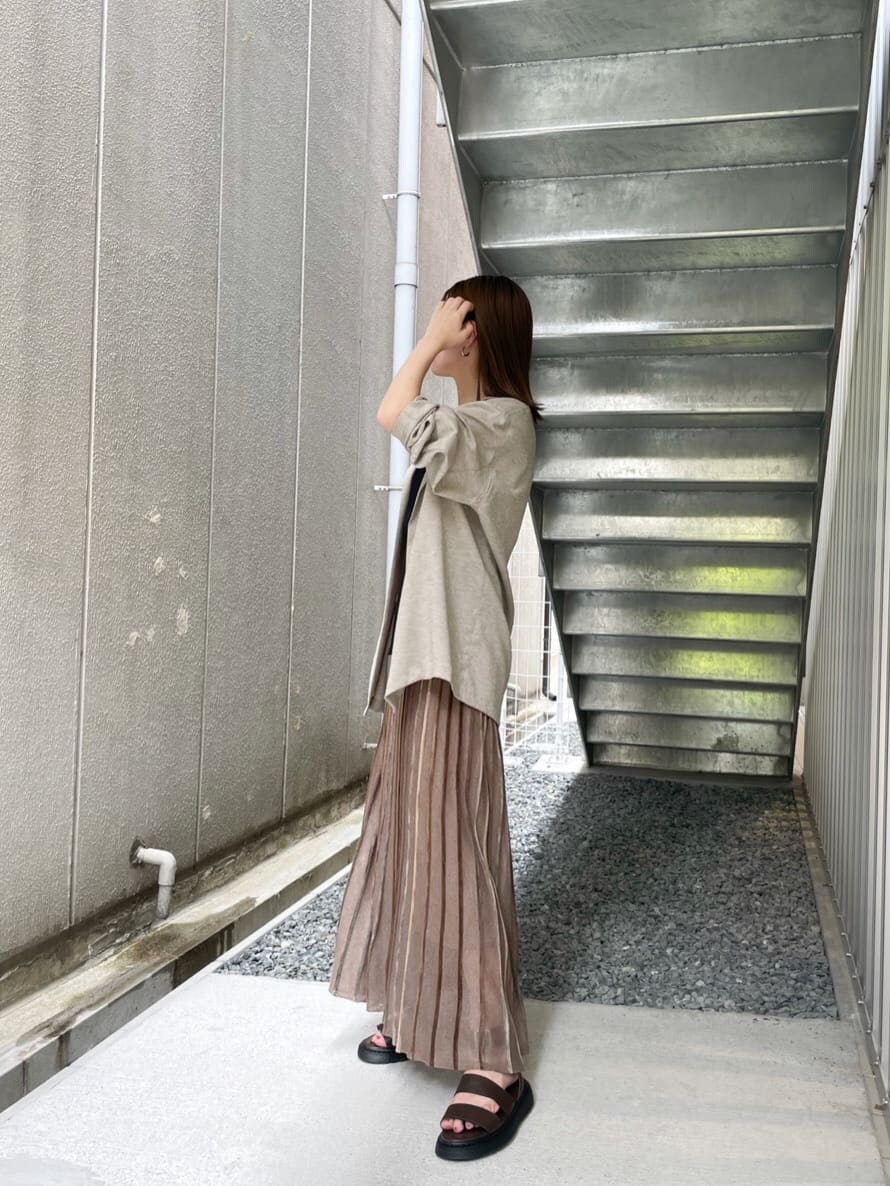 ブラウン系のスカート、ブラック系のニット/セーター、ブラウン系のサンダルを着用したレディースの夏コーディネートの6枚目の写真