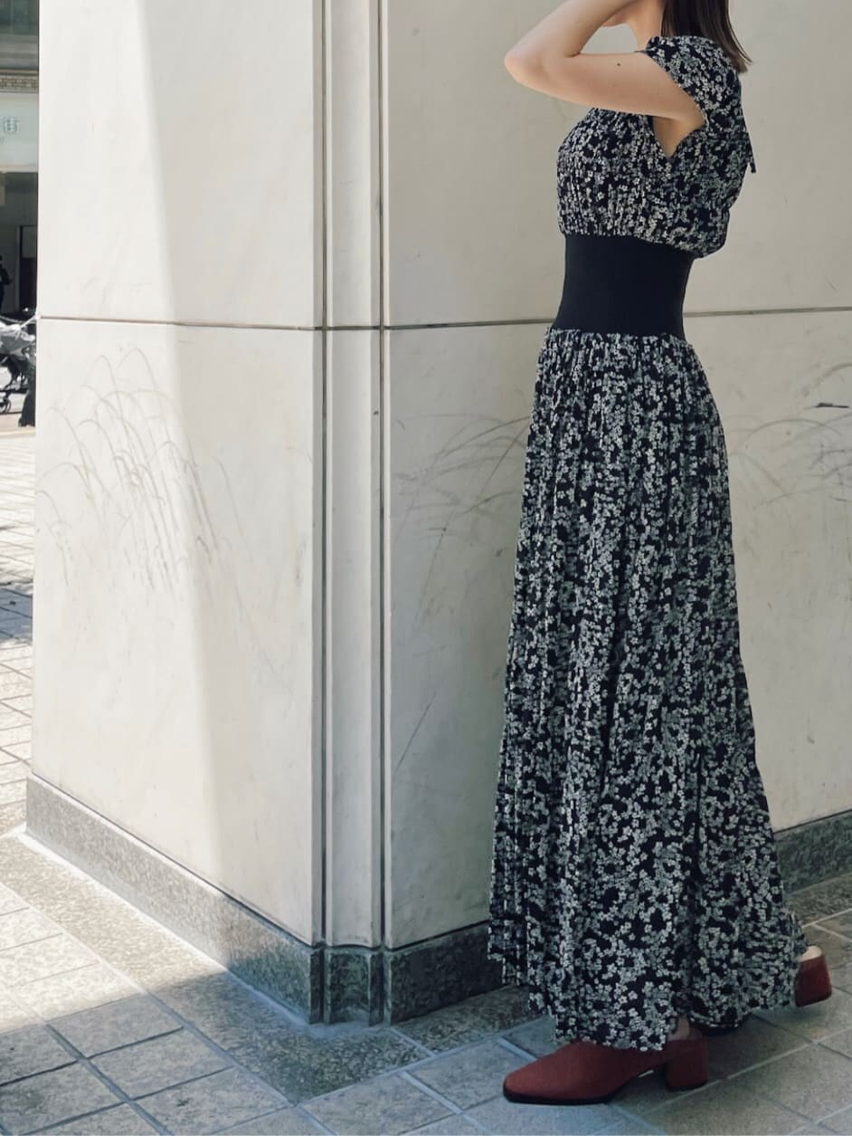 ブラック系のハンドバッグ、ブラック系のワンピース、オレンジ系のスリッポンを着用したレディースの夏コーディネートの7枚目の写真