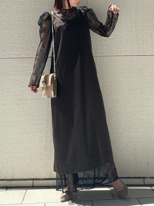 ブラック系のドレス、ベージュ系のパンプス、ベージュ系のクラッチバッグを着用したレディースの秋コーディネートの7枚目の写真