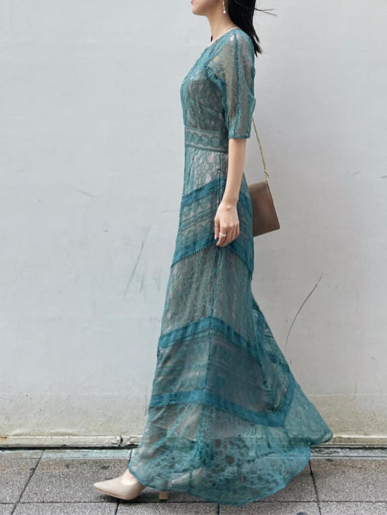 グリーン系のドレス、ベージュ系のパンプス、ブラウン系のクラッチバッグを着用したレディースの夏コーディネートの6枚目の写真