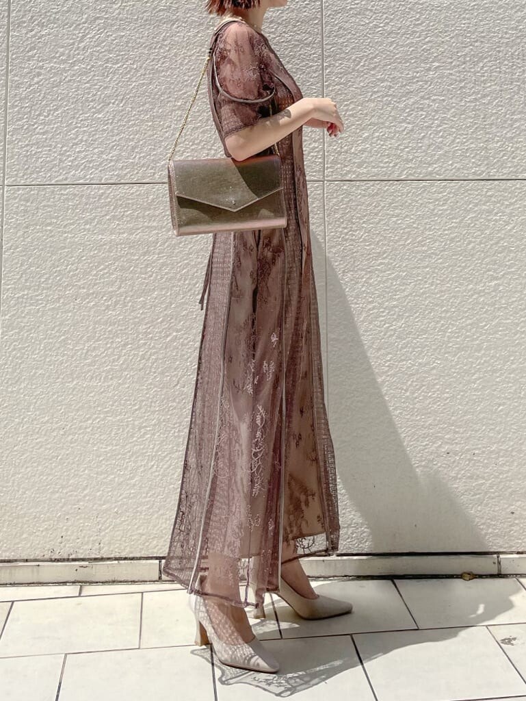 ベージュ系のパンプス、ゴールド系のクラッチバッグ、ベージュ系のドレスを着用したレディースの夏コーディネートの6枚目の写真